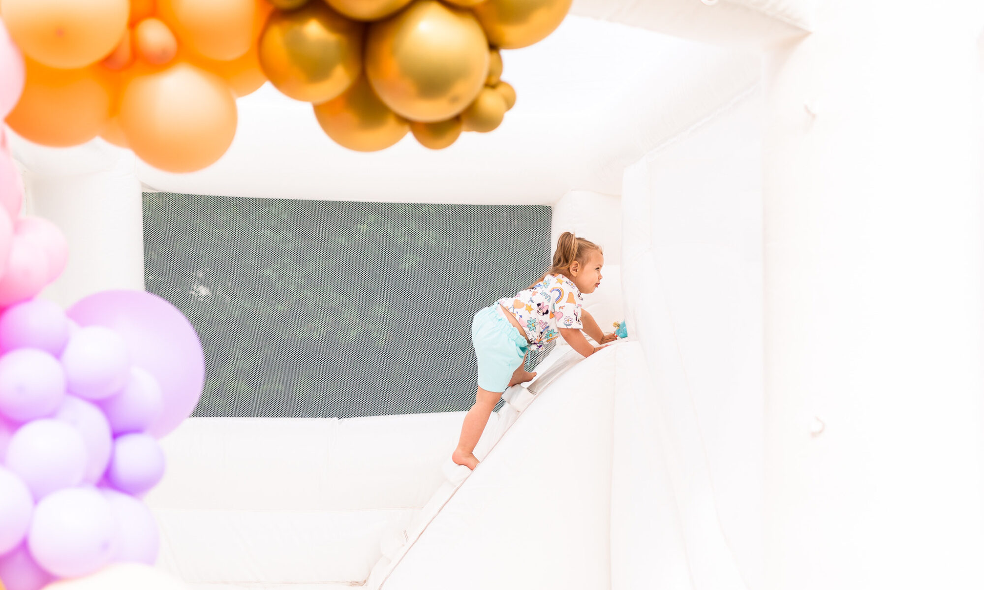 Toddler Climbing in the White Bounce House